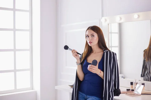 Closeup portrait of woman with makeup brush near face — Stock Photo, Image