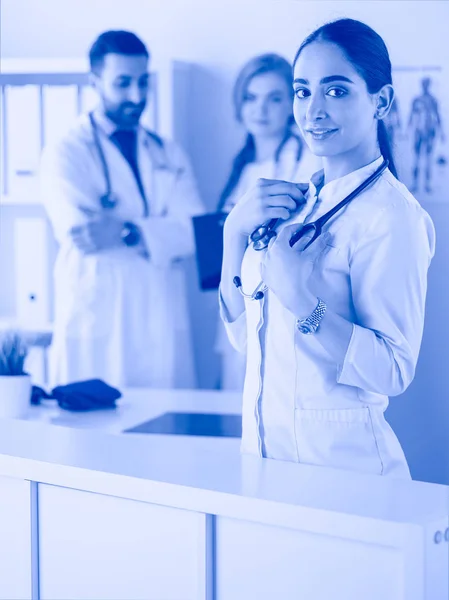 Attractive female doctor in front of medical group — Stock Photo, Image