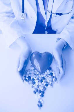 Masada kırmızı kalbi ve steteskopu olan kardiyolog.