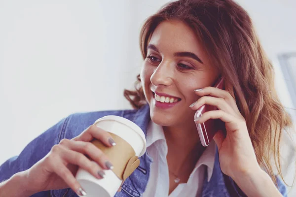 Νεαρή γυναίκα στο καφέ πίνοντας καφέ και μιλώντας στο κινητό — Φωτογραφία Αρχείου