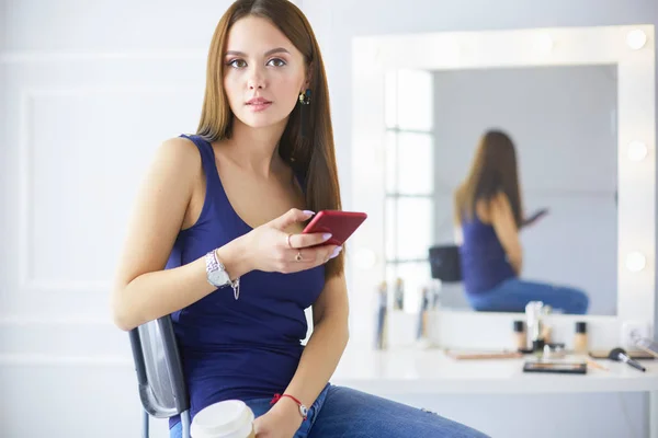 Mujer joven en la cafetería bebiendo café y hablando por teléfono móvil — Foto de Stock