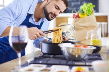 Adam ev mutfağında lezzetli ve sağlıklı yemekler hazırlıyor.