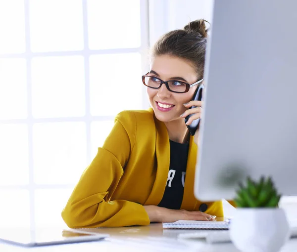 Empresaria sentada en oficina con laptop por teléfono —  Fotos de Stock