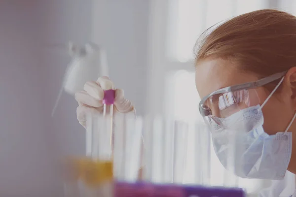 Chercheur médical ou scientifique ou médecin examinant une éprouvette de solution verte liquide dans un laboratoire — Photo
