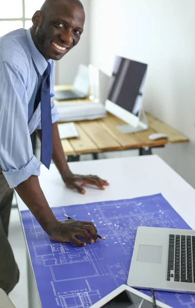 アフリカ系アメリカ人の建築家がオフィスでコンピュータと設計図を使って — ストック写真
