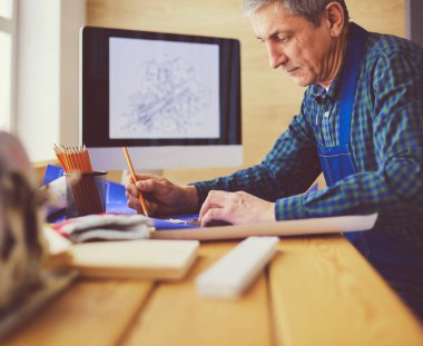 Ofisteki çizim masasında çalışan mimar