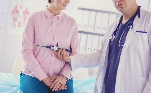 Врач показывает молодому пациенту ее грудь в его кабинете в больнице — стоковое фото