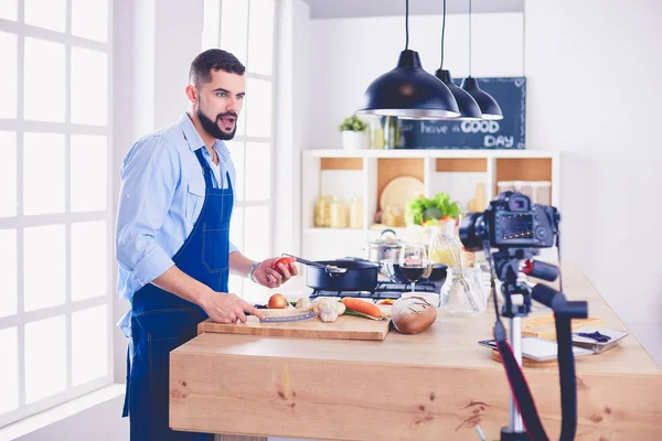 Man holding paper bag full of groceries on the kitchen background. Shopping and healthy food concept — Stock Photo, Image