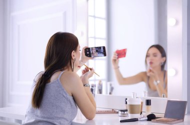 Ayna önünde akıllı telefon ile makyaj eğitimi filme Güzellik blogger