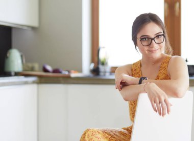 Mutfakta masada oturan genç bir kadın.