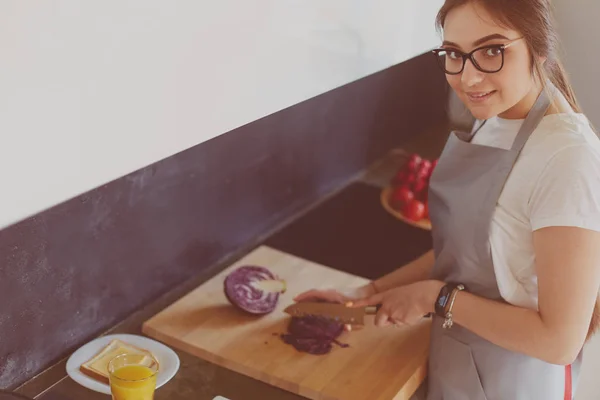タブレットを使って台所で料理をする若い女性 — ストック写真
