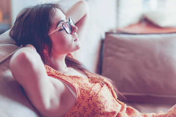 Relaxed woman sitting on a modern sofa at home — Stock Photo, Image
