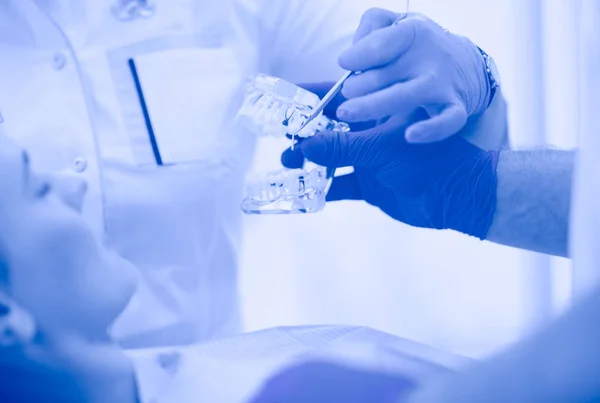 Médico dentista sênior em consultório odontológico conversando com paciente do sexo feminino e se preparando para o tratamento — Fotografia de Stock