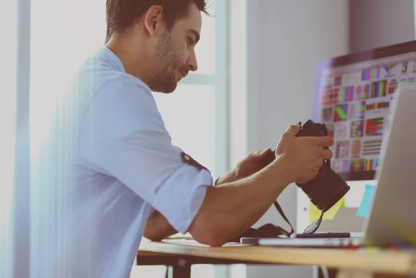 Porträt eines jungen Designers, der im Grafikstudio vor Laptop und Computer sitzt, während er online arbeitet. — Stockfoto