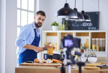 Mutfak arka planında poşet dolusu erzak tutan adam. Alışveriş ve sağlıklı gıda konsepti