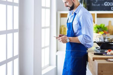 Mutfak arka planında poşet dolusu erzak tutan adam. Alışveriş ve sağlıklı gıda konsepti