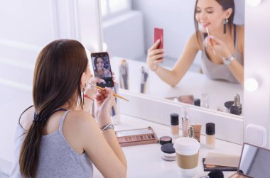 Ayna önünde akıllı telefon ile makyaj eğitimi filme Güzellik blogger