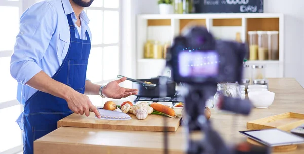 Mann hält Papiertüte voller Lebensmittel auf dem Küchenhintergrund. Shopping und gesundes Ernährungskonzept — Stockfoto