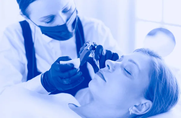 Cosmetologist applying permanent make up on eyebrows — Stock Photo, Image