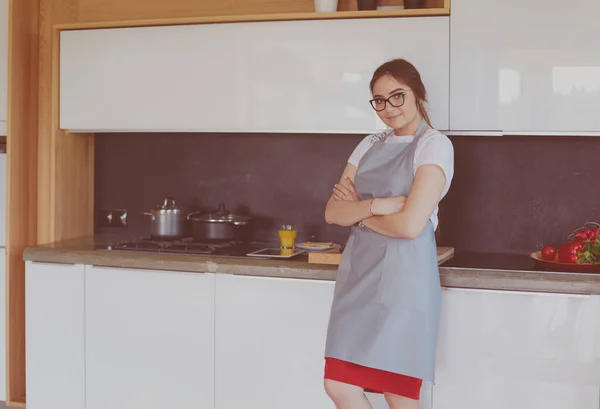 与厨房背景交叉的年轻女子的画像 — 图库照片