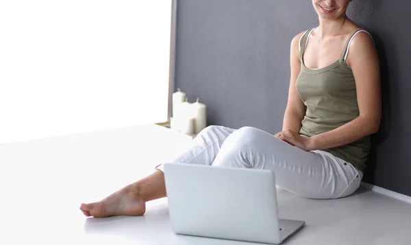 Una giovane donna sdraiata sul pavimento con un computer portatile — Foto Stock