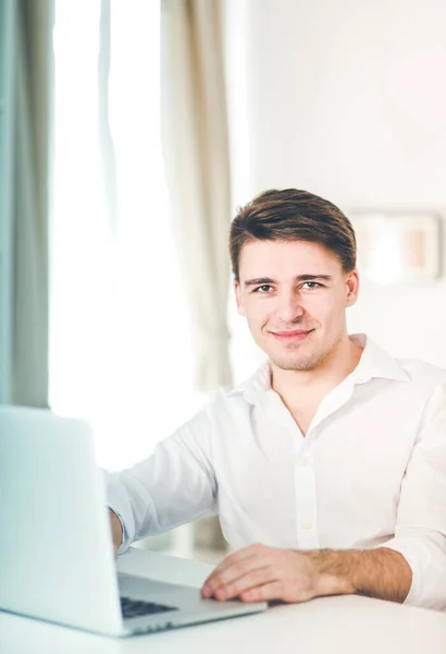 ラップトップコンピュータを使用してオフィスデスクに座っている事務職員の男性の肖像 — ストック写真