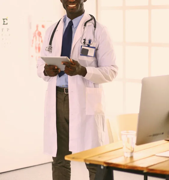 Male black doctor worker with tablet computer standing in hospital