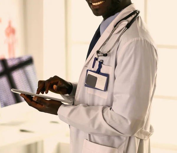 Male black doctor worker with tablet computer standing in hospital