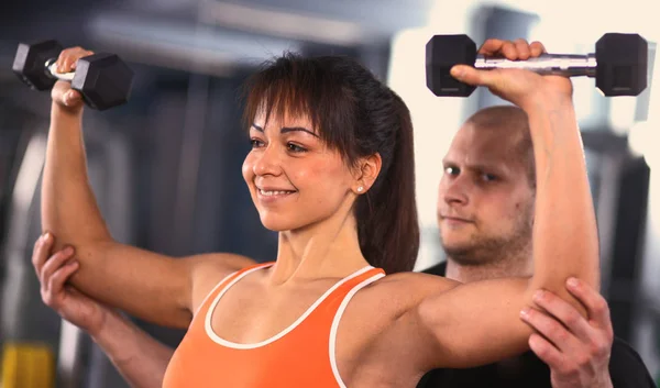 Schöne Frau im Fitnessstudio, die mit ihrem Trainer trainiert. schöne Frau. — Stockfoto