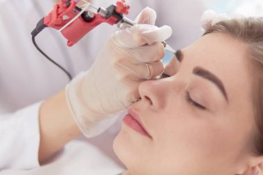 Kırmızı dudaklı genç bir kız kalıcı makyaj, mikro pigmentasyon