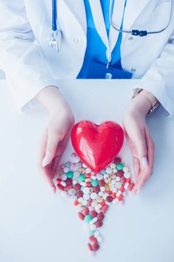 Masada kırmızı kalbi ve steteskopu olan kardiyolog.