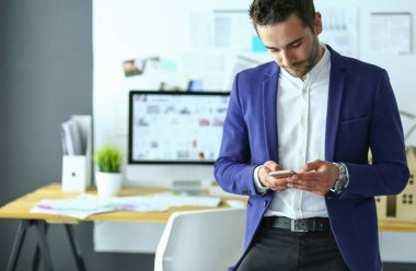 Dizüstü bilgisayar ve bilgisayar çalışırken önünde genç tasarımcı portresi.