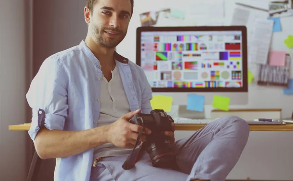 Porträt eines jungen Designers, der im Grafikstudio vor Laptop und Computer sitzt, während er online arbeitet. — Stockfoto