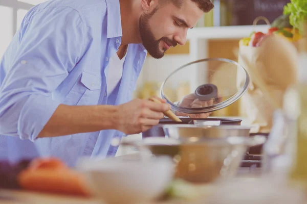 Dijital tablet ve yemek pişirme tarifine uyan bir adam evdeki mutfakta lezzetli ve sağlıklı yemekler pişiriyor. — Stok fotoğraf