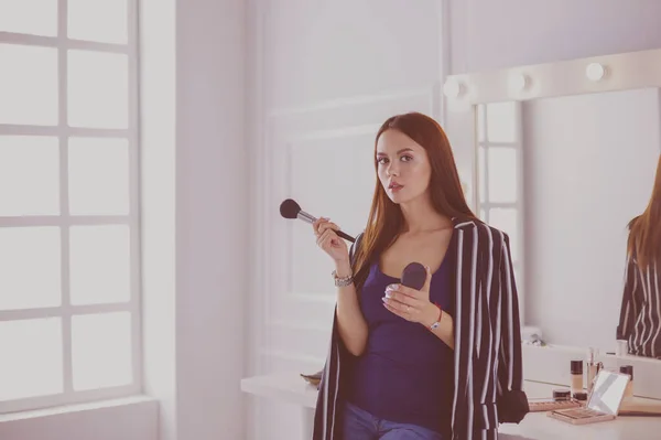 Closeup portrait of woman with makeup brush near face — Stock Photo, Image