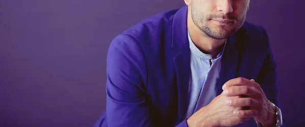 Joven empresario sentado aislado sobre fondo gris. —  Fotos de Stock