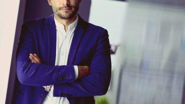 Dizüstü bilgisayar ve bilgisayar çalışırken önünde genç tasarımcı portresi.