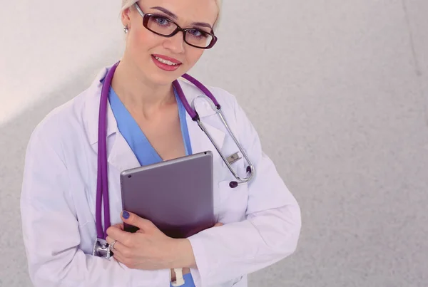 Médico femenino usando una tableta digital y de pie sobre fondo blanco. Mujeres doctores. — Foto de Stock