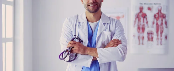 Retrato médico masculino joven y confiado parado en el médico apagado — Foto de Stock