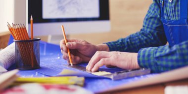 Ofisteki çizim masasında çalışan mimar