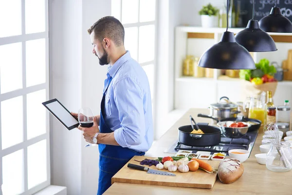 Man efter recept på digital tablett och matlagning välsmakande och hälsosam mat i köket hemma — Stockfoto