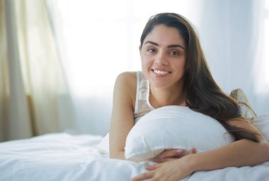 Güzel bir kadın yatağında uzanıyor.