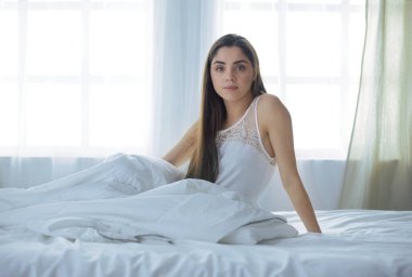 Güzel bir kadın yatağında uzanıyor.