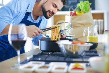 Adam ev mutfağında lezzetli ve sağlıklı yemekler hazırlıyor.
