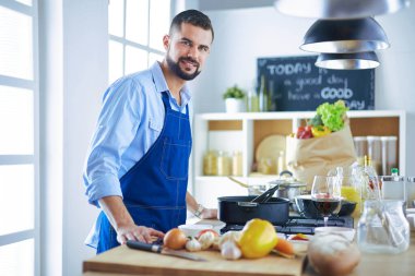 Adam ev mutfağında lezzetli ve sağlıklı yemekler hazırlıyor.