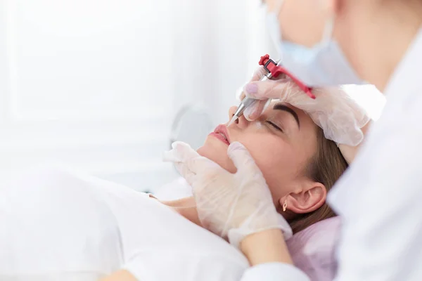 En ung flicka med röda läppar permanent makeup, mikropigmentering — Stockfoto