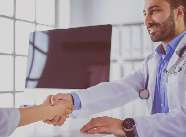 Doctor shaking hands to patient in the office at desk — Stock Photo, Image