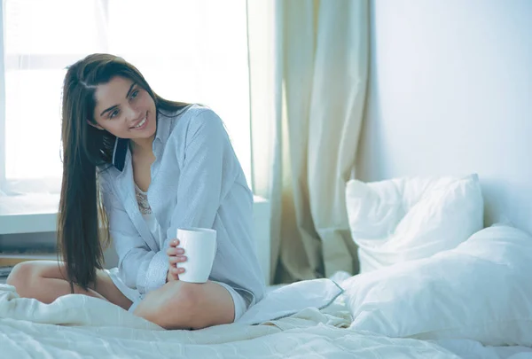 Wanita duduk di tempat tidur membaca buku dan sarapan — Stok Foto