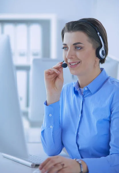 Ernstige mooie jonge vrouw die werkt als support telefoon operator met headset in het kantoor — Stockfoto