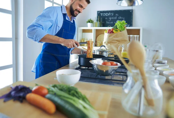 Человек готовит вкусную и здоровую пищу на домашней кухне — стоковое фото